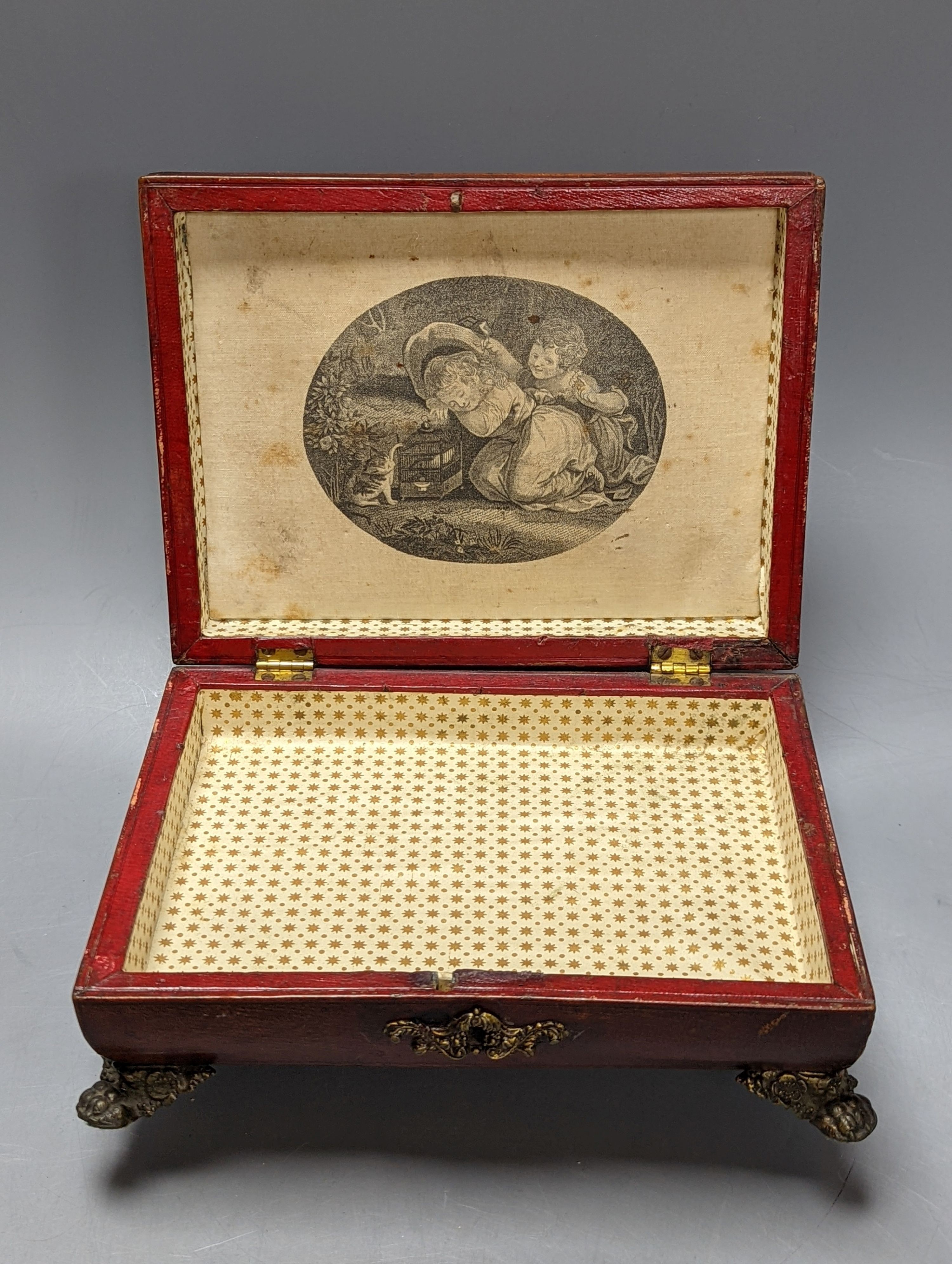 A George IV tooled Morocco leather box, with a silk printed cartouche to interior of the lid, 22 cms wide at base x 12 cms high.